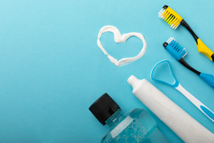A vibrant blue background showcasing toothbrushes, toothpaste tubes, and toothbrush holders in an organized arrangement.