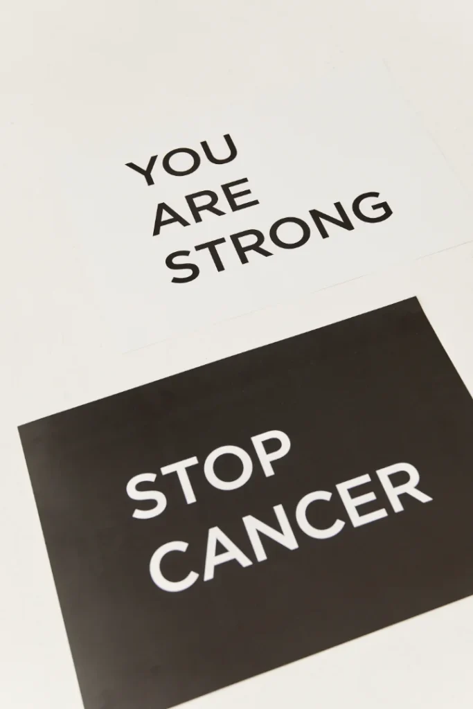 A black and white sign board with You Are Strong Stop Cancer written on them