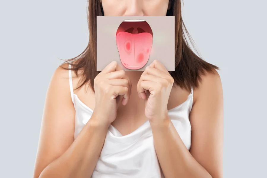 A person holding a piece of paper with a tongue cut out of it