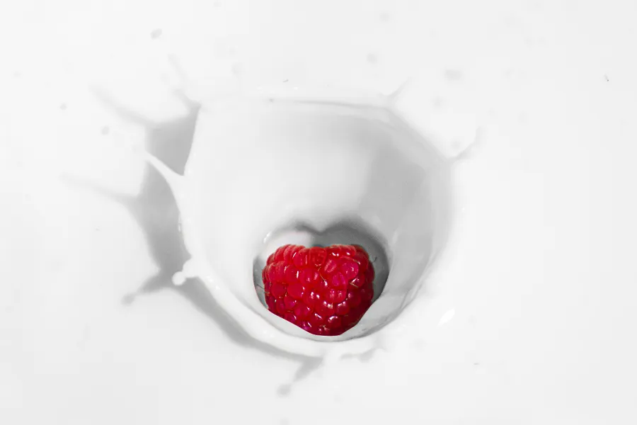 A raspberry in a milk splash