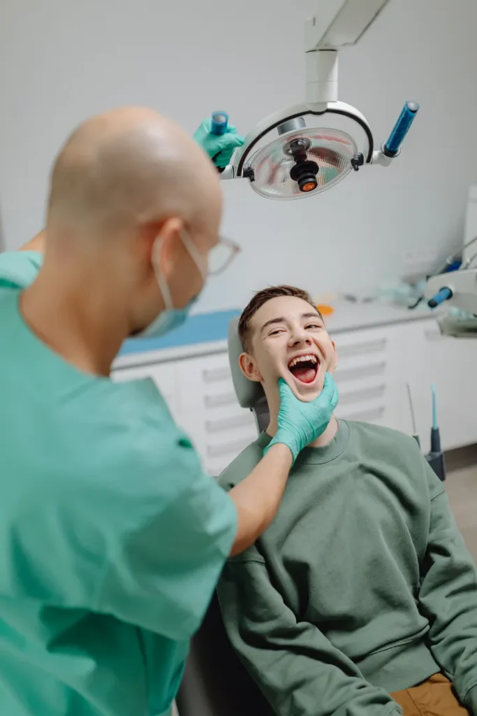 A patient chuckling as a dentist examines his teeth