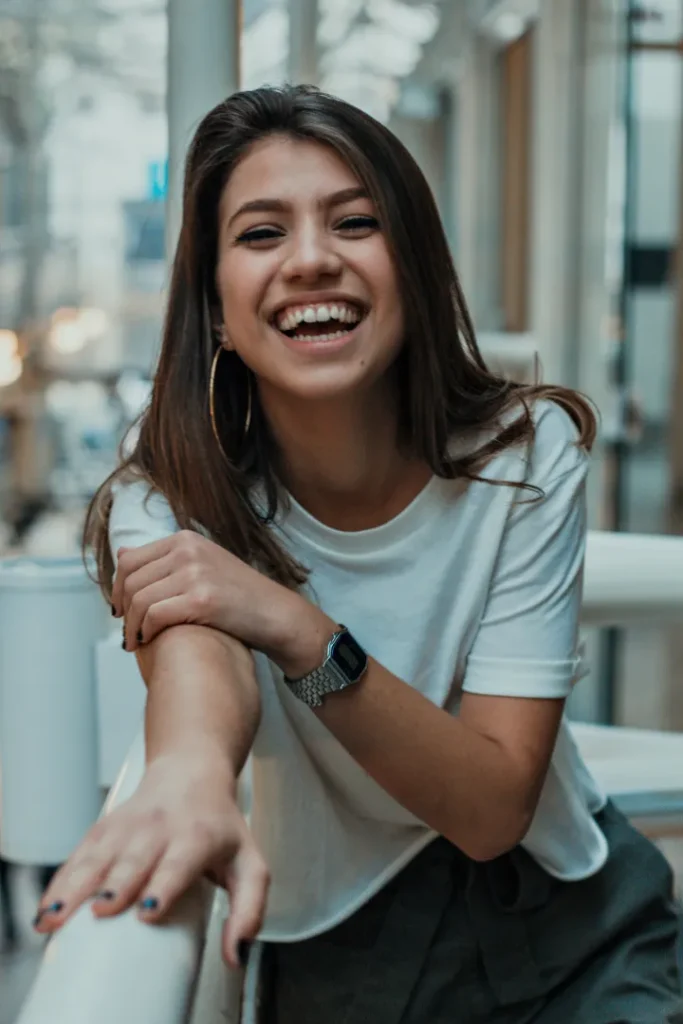 Smiling woman perched on a railing